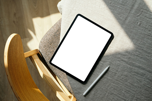 Mockup of tablet with blank screen and drawing pencil on table. freelancer home office desk top view. Modern workspace.
