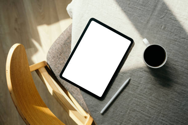 istock Flat lay, top view feminine workspace with blank screen tablet mockup, drawing pencil, cup of coffee, wooden chair. Cozy home office desk. Nordic, Scandinavian interior 1316569043