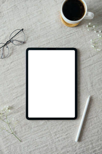 istock Blank screen tablet mockup, drawing pencil, glasses, coffee cup on linen tablecloth. Flat lay, top view. Elegant feminine workspace, nordic style 1316569055
