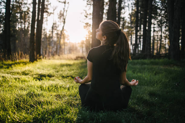 istock Young woman meditating in nature 1316569799