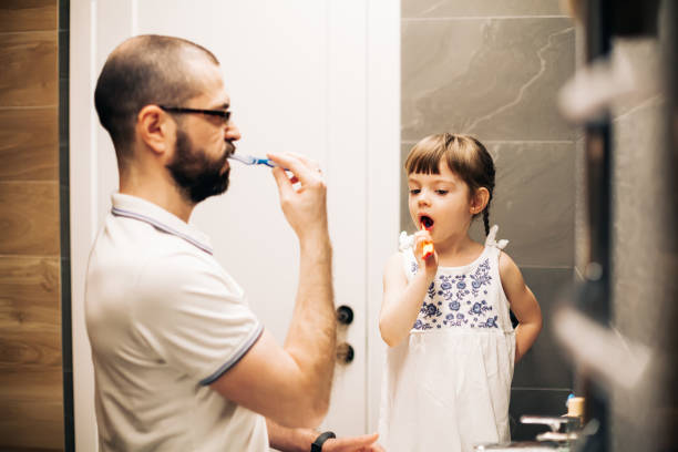 istock Bearded father and his little daughter brushing teeth 1316570923