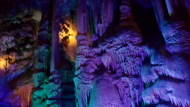 mundo místico de cueva de goteo con luces de colores - dripstone fotografías e imágenes de stock