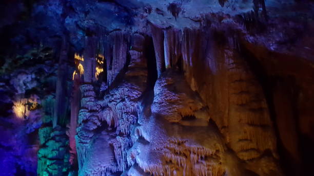 istock stalactites and stalagmites in cave with purple light 1316572191