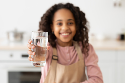 5 years old girl holding glass of milk