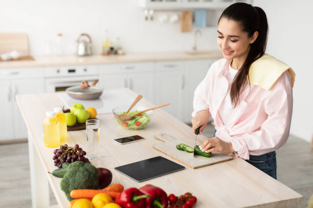 istock Woman cooking salad and using tablet and kitchen 1316572629