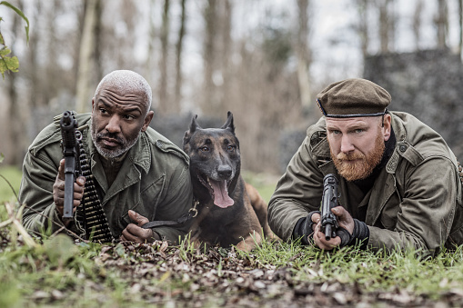 A redhead military male soldier and a black captain during an outdoor operation in the autumn