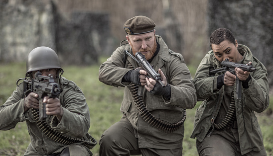 A redhead military male soldier, a black captain and female agent during an outdoor operation in the autumn