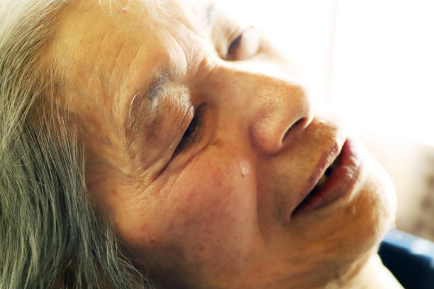 Smiling senior woman sleeping in bed at home