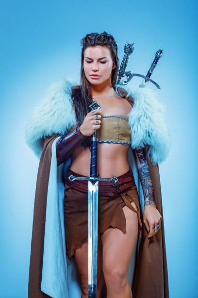 istock Sword wielding viking warrior brunette female in studio shot 1316575344