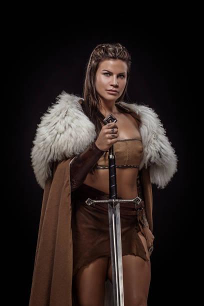 istock Sword wielding viking warrior brunette female in studio shot 1316575380