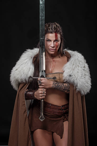 istock Sword wielding viking warrior brunette female in studio shot 1316575392