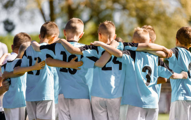 kids team members in sport team. happy boys huddling in football team. children standing in a circle together. kids motivational speech before the match - youth league fotos imagens e fotografias de stock