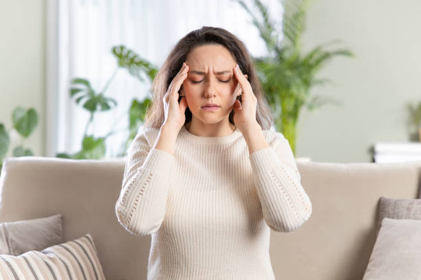 istock Young woman with headache sitting on sofa 1316575443
