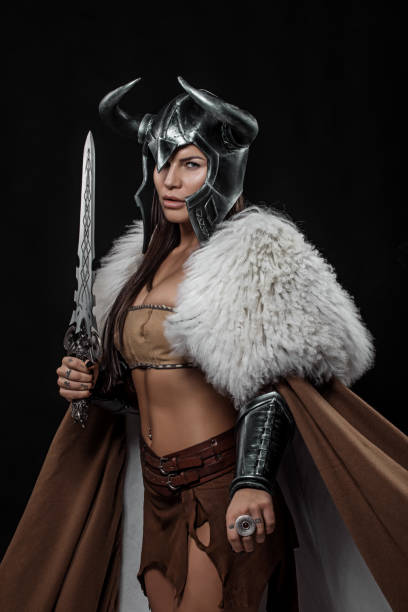istock Sword wielding viking warrior brunette female in studio shot 1316575448