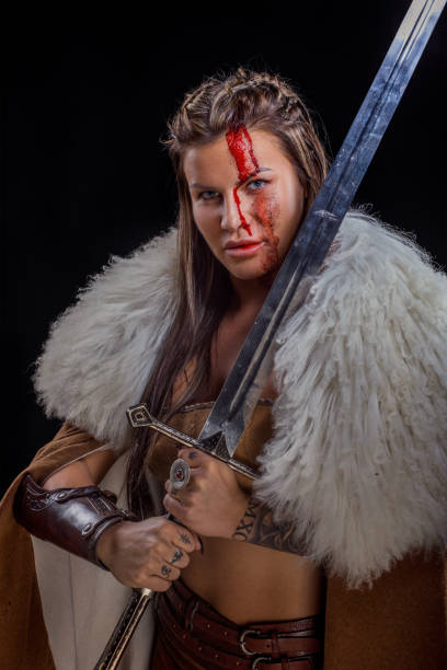 istock Sword wielding viking warrior brunette female in studio shot 1316575979