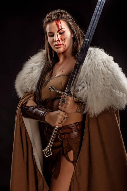 istock Sword wielding viking warrior brunette female in studio shot 1316576042