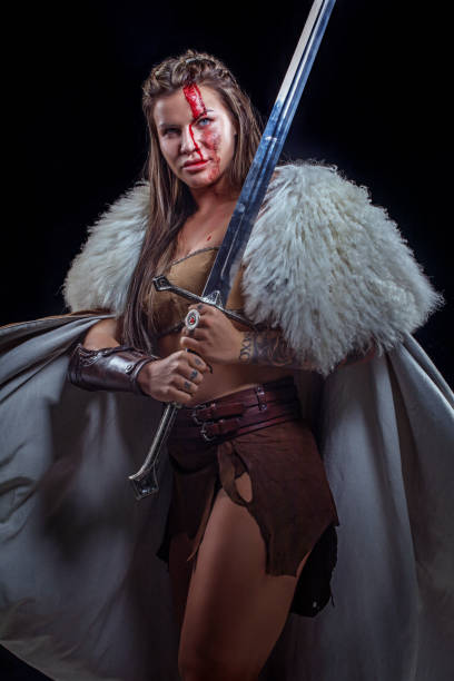 istock Sword wielding viking warrior brunette female in studio shot 1316576044