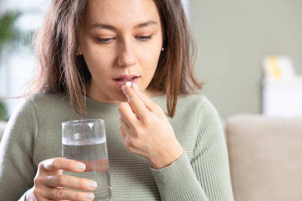 istock Young woman taking pill 1316576154