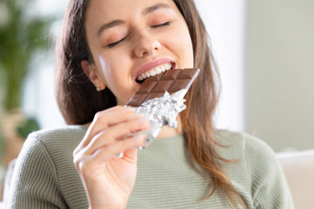istock Woman biting a chocolate bar 1316576208