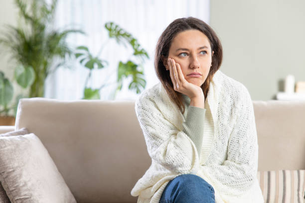 istock Depressed young woman on sofa at home 1316576367