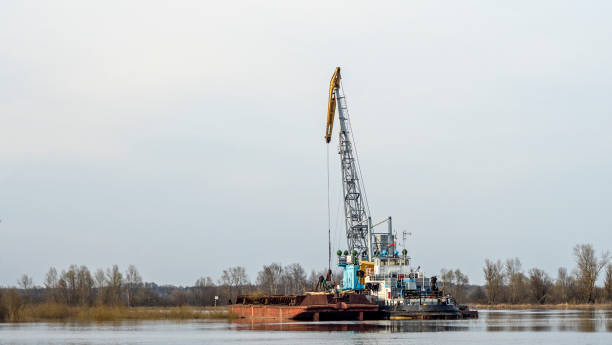 istock Dredger is working to deepen the fairway on the river. Cleaning and deepening by a dredger on the river. Sunset on the river. Industrial concept. 1316577953