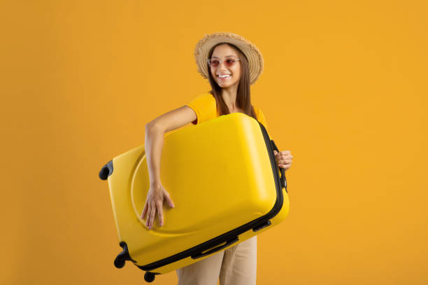 istock Pretty young woman holding suitcase and smiling 1316578889