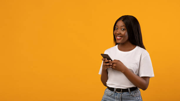 istock Beautiful black lady in white t-shirt using smartphone 1316579254