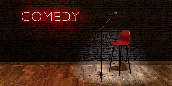 stage with microphone and stool illuminated by a spotlight with the word COMEDY on a red neon lamp and brick wall. . space for text. 3d render