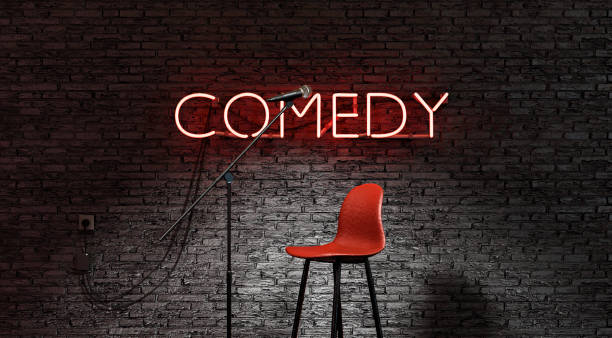 stage lit by a spotlight and a red neon lamp with the word COMEDY Stand-up comedy stage illuminated by a spotlight with the word COMEDY in red neon lamp. 3d render fashion show stock pictures, royalty-free photos & images