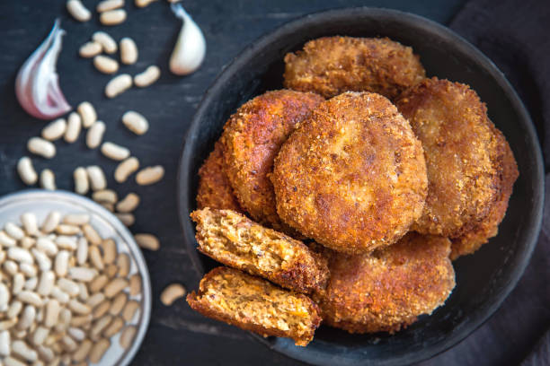 istock Vegetarian bean patties or cutlets on a black plate. Top view 1316581339