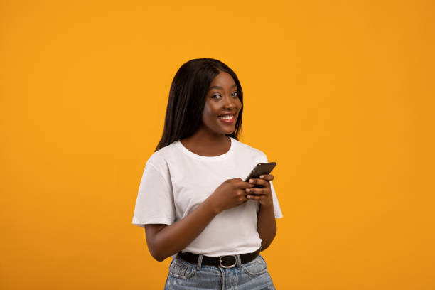 istock Excited black lady holding smartphone in her hand 1316581445