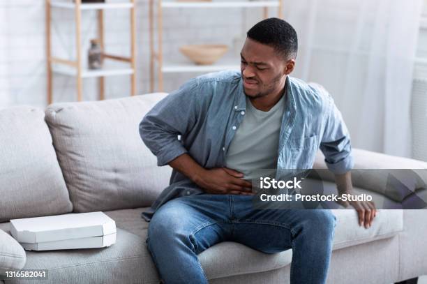 Afroamerikaner Kerl Mit Magenschmerzen Nach Dem Essen Pizza Zu Hause Stockfoto und mehr Bilder von Bauchschmerzen