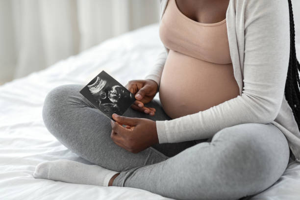 태아 발달. 임신 한 아프리카 여자 보고 에 아기 초음파 검사 에 집에서 - abdomen gynecological examination women loving 뉴스 사진 이미지