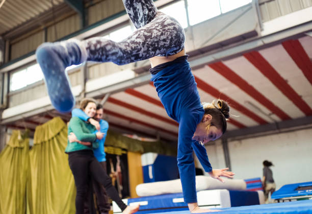 istock Young female circus school student performs cartwheel observed by her classmates 1316582957