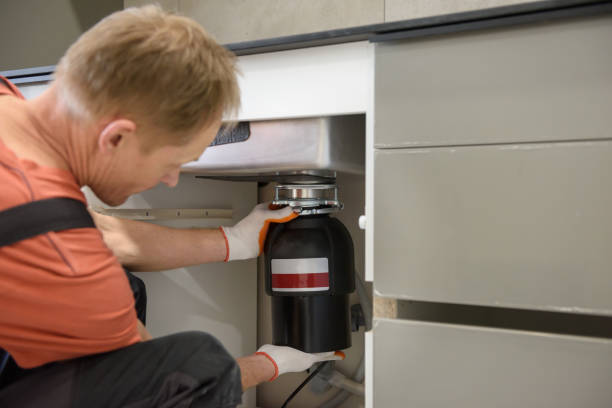 istock The worker is installing a household waste shredder for the kitchen sink. 1316584201