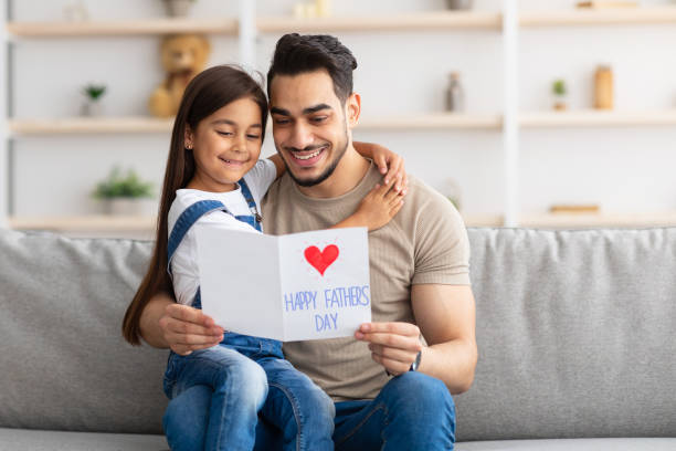 istock Happy little daughter greeting young dad with card 1316584740
