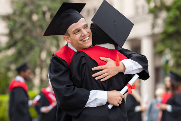 istock Happy guys students greeting each other with graduation 1316586108
