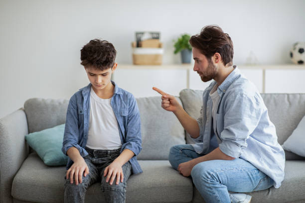 istock Family discipline concept. Grumpy dad scolding his offended son, teaching his kid tolerance, respect, well-behaving 1316586912