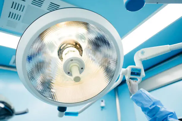 Photo of Dentist adjusting lamp in dentists office.