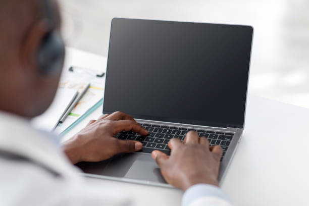 conferência online. médico afro-americano usando laptop com tela em branco, espaço vazio - ecrã em branco - fotografias e filmes do acervo