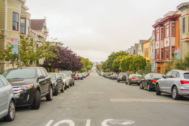 poziome ujęcie pięknej drogi z drzewami, zaparkowanymi samochodami i tradycyjnymi domami w san francisco po obu stronach, kalifornia - stany zjednoczone ameryki aka usa - castro street zdjęcia i obrazy z banku zdjęć