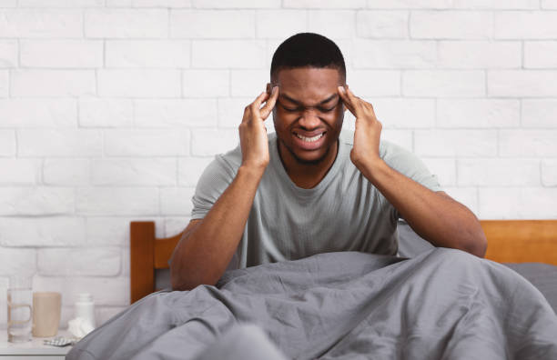 istock African Man Suffering From Headache Massaging Temples Sitting In Bedroom 1316591601