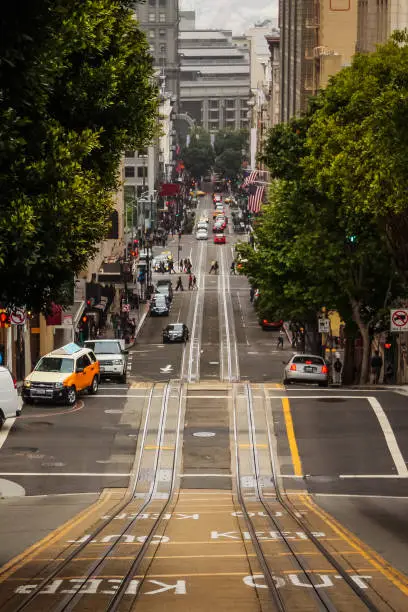 Photo of A vertical shot of a street sloping downwards in the busy city of San Francisco, California, United States of America aka USA