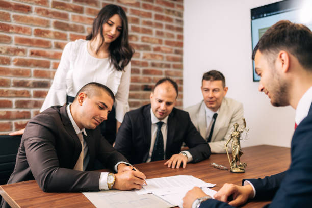 Business people negotiating a contract Close up of lawyer signing formal paper on the office table witness signature stock pictures, royalty-free photos & images