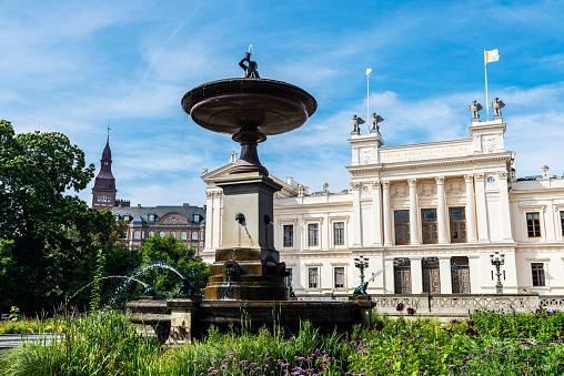 Lund, Sweden - August 30, 2019: Fountain and the classic facade of the main buiding of the Lund University in Lund, Scania, Sweden