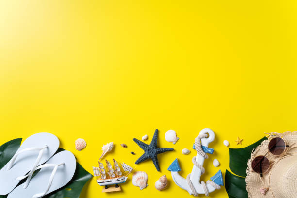 istock Summer beach design concept with shells, hat, slipper on yellow background. 1316594389