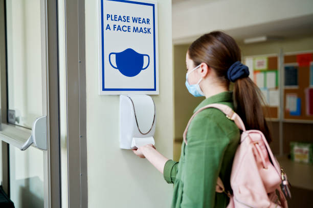 istock Girl wearing face mask disinfect their hands 1316594706