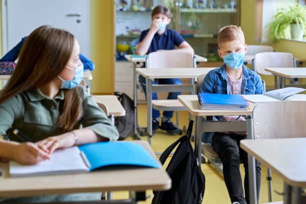 istock School children in protective face masks sitting in the classroom 1316594992