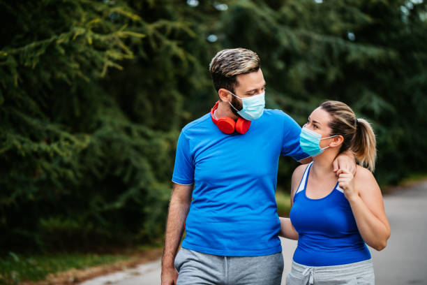 istock Couple with face mask walking embraced 1316597754