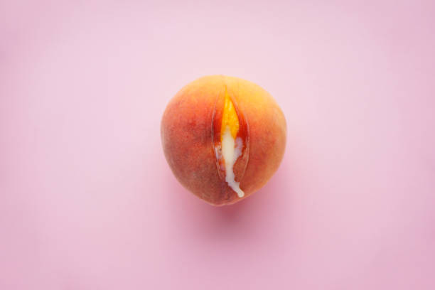 Juicy peach and condensed milk on a pink background, flat lay. Sex concept. stock photo
